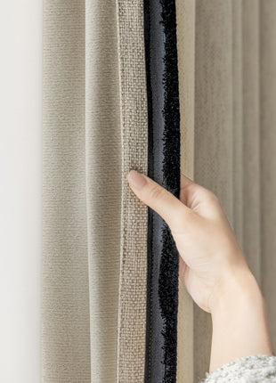 a person's hand is holding a curtain in front of a window