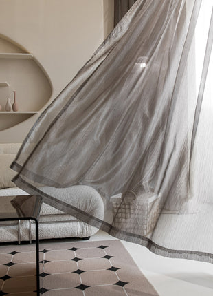 a living room filled with furniture and a sheer curtain