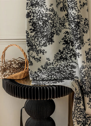 a basket sitting on a table next to a curtain