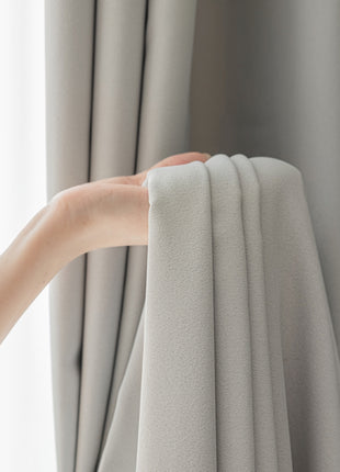 a person holding a curtain with their hand