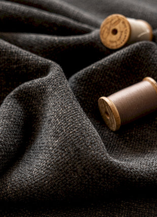 two spools of thread sitting on top of a gray cloth