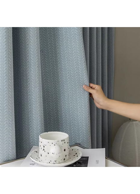 a person is holding a coffee cup in front of a curtain