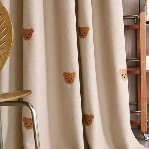 a room with a chair and a curtain with teddy bears on it