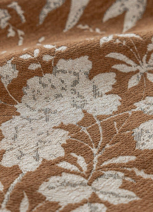 a close up of a brown and white flowered fabric