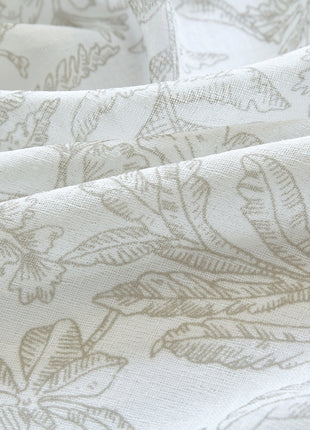 a close up of a white fabric with leaves on it