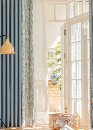 a living room with blue curtains and a white chair