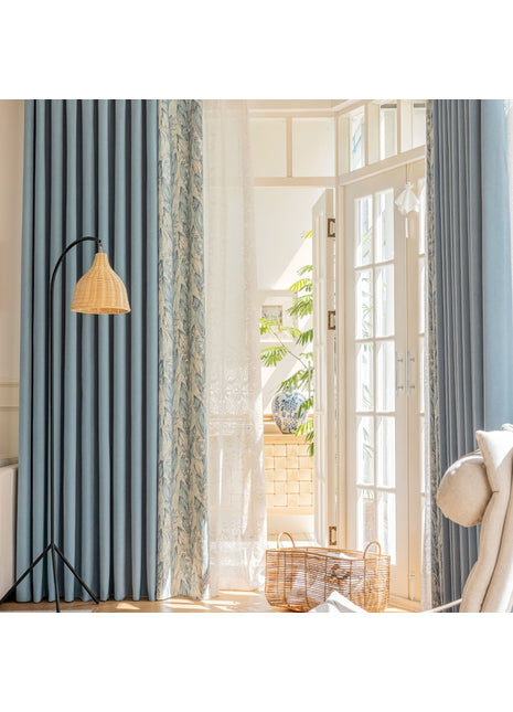 a living room with blue curtains and a white chair