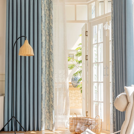 a living room with blue curtains and a white chair