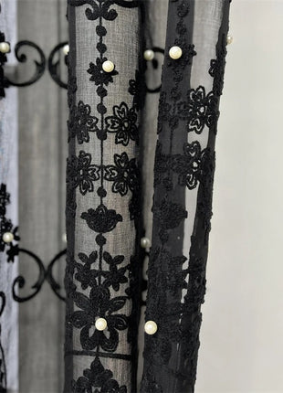 a curtain with black lace and pearls on it