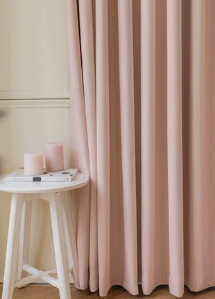a white table sitting next to a pink curtain