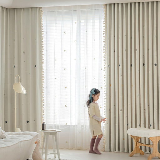 a little girl standing in front of a window