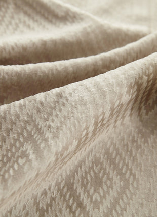 a bottle of lotion sitting on top of a blanket