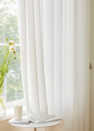 a vase of flowers sitting on a table next to a window