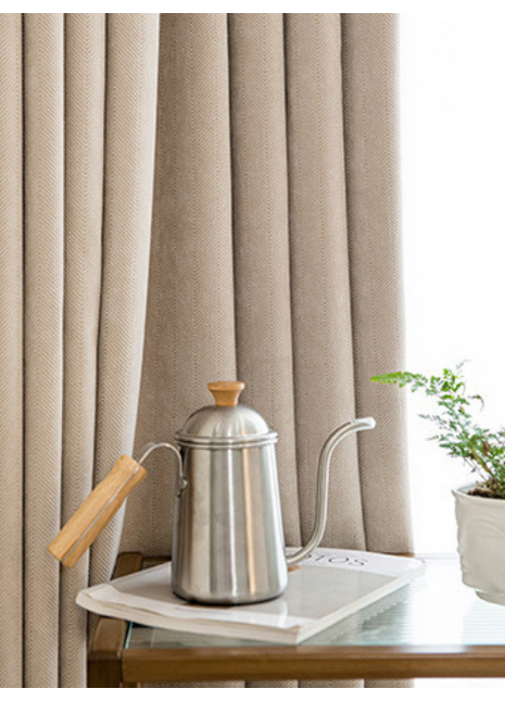 a silver kettle with a wooden handle, placed on a white tray, and a small potted plant next to it.