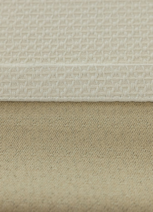 a close up of a bed with a beige cover
