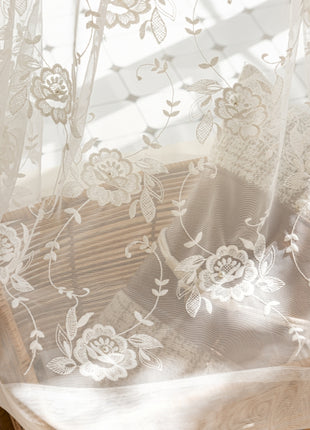 a close up of a sheer curtain with flowers on it