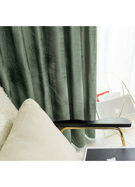Rideau occultant en velours vert sapin dans un salon, voilage blanc et table basse dorée