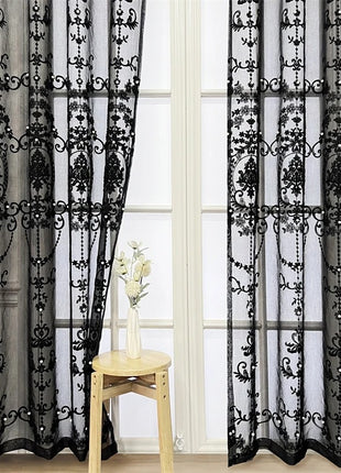 a window with sheer curtains and a vase of flowers