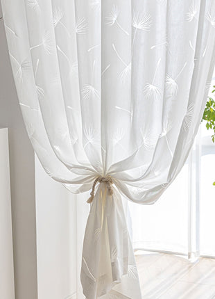 a white curtain hanging from a window next to a potted plant