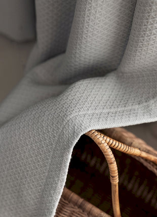 a wicker basket with a blanket on top of it