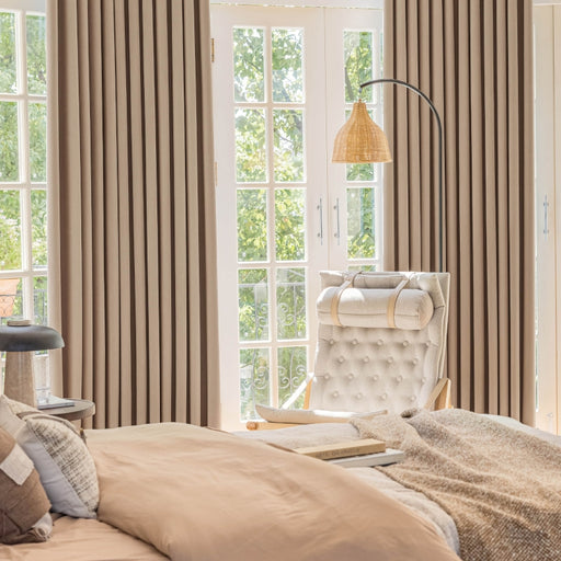 a bedroom with a bed, chair and window