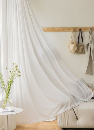 a living room with a white couch and a white curtain