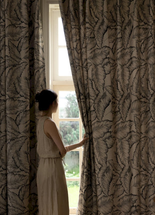 a woman standing in front of a window looking out