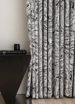 a black and white curtain next to a black table