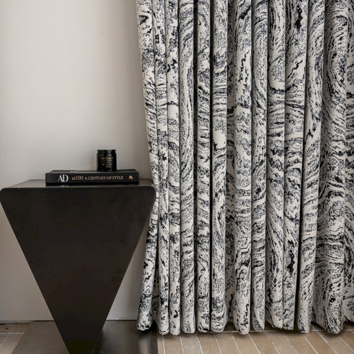 a black and white curtain next to a black table