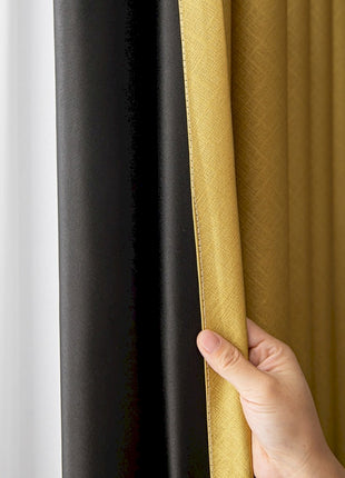 a hand holding a curtain with a black and yellow color