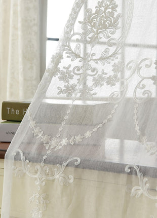 a window with a white curtain and a book on a table