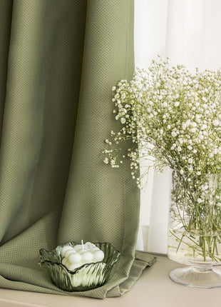a vase of flowers sitting on a table next to a curtain