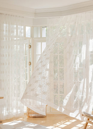 a room with a white curtain and a chair