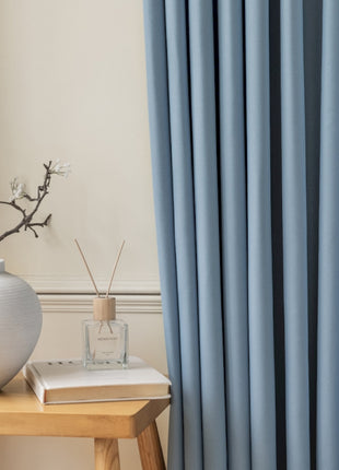 a white vase sitting on top of a wooden table