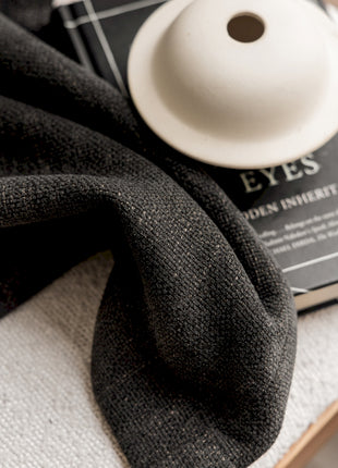 a black scarf and a white button on a table