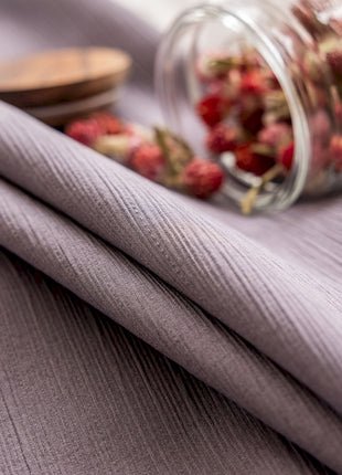 a glass jar filled with flowers sitting on top of a bed