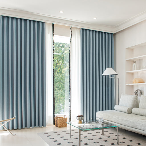 a living room with a white couch and blue curtains