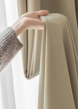 a person is holding a curtain in front of a window