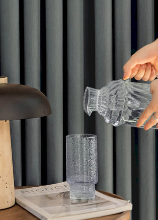 a woman is pouring water into a glass