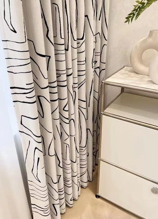 a white dresser sitting next to a window covered in curtains