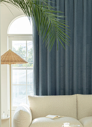 a living room with a white couch and a palm tree