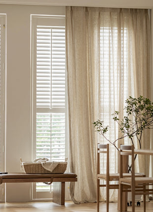 a living room filled with furniture and a window covered in blinds