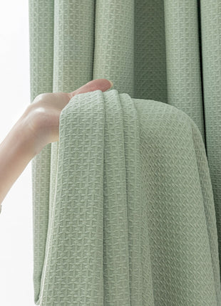 a hand reaching for a curtain in front of a window