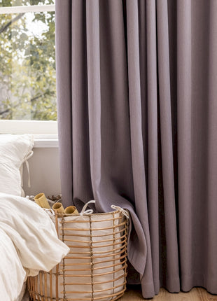 a bedroom with a bed, a basket, and a window