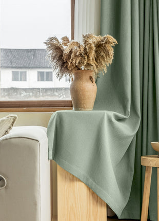 a living room with a couch and a vase with flowers in it