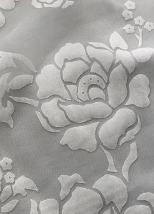 a close up of a white flower on a gray background