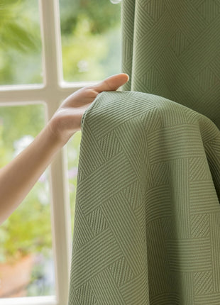 a person's hand is holding a curtain in front of a window