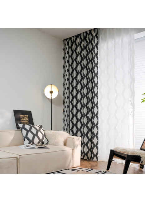 a living room with a white couch and black and white curtains