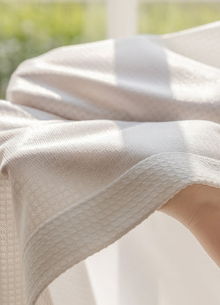 a person's hand under a blanket on a bed