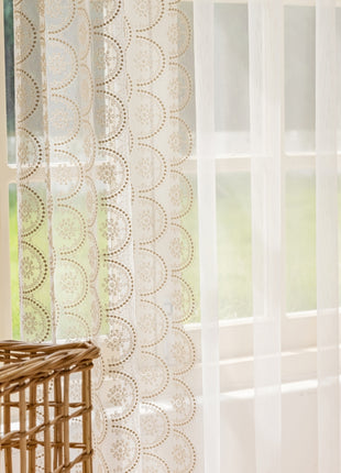 a window with sheer curtains and a basket in front of it